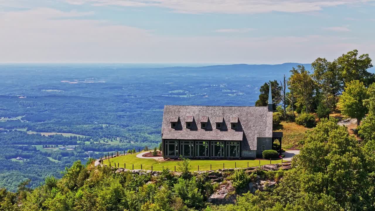 여자는 절벽을 향해 걸어가서 예배당 앞의 아름다운 풍경을 즐긴다.