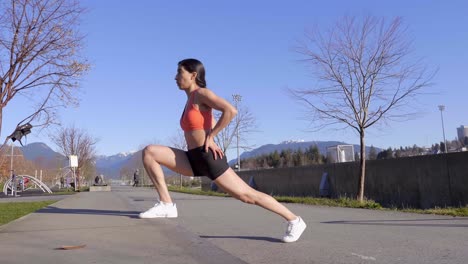 athletic young woman stretching legs on curb