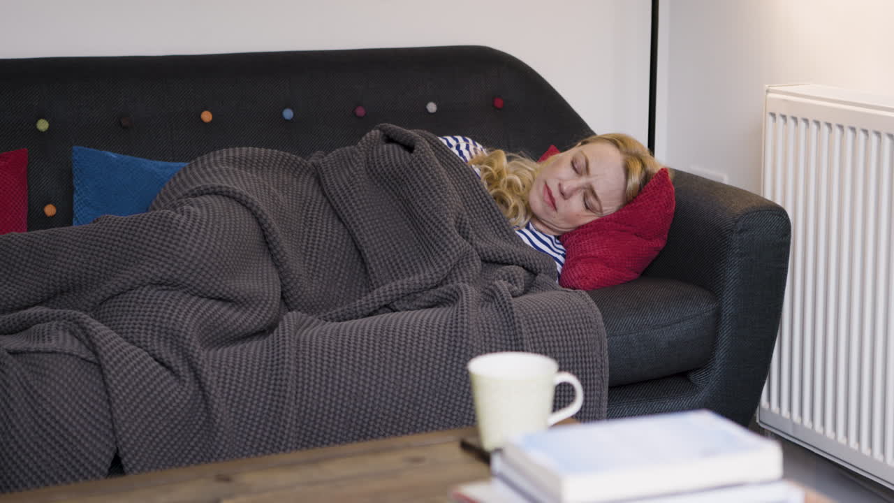 Woman sleeping on couch with blanket