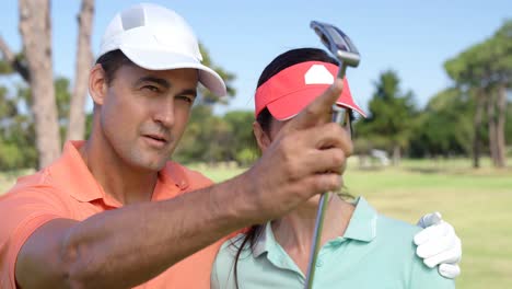 pareja feliz interactuando entre sí mientras juegan al golf