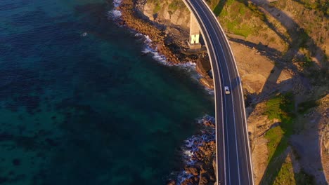 bridge along cliff edge and ocean with cars driving - sea cliff bridge in illawarra region, new south wales, australia