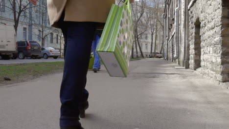 Mujer-Caminando-Por-La-Ciudad-Y-Llevando-Una-Bolsa-De-Compras.