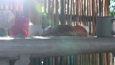 cups-of-hot-tea-with-evaporating-water-and-a-bun,-side-view,-flares