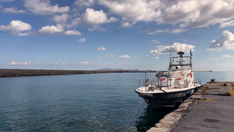 boat docked at heraklion port with calm waters and clouds, crete, greece