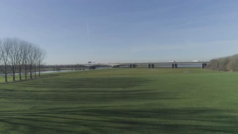 Drohnenaufnahme-Einer-Autobahnbrücke-Auf-Einem-Wunderschönen-Rasenfeld