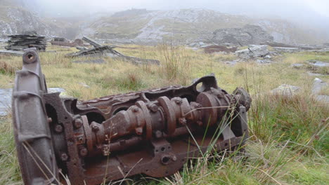 A-rusted-piece-of-recked-machinery-lying-on-a-welsh-mountainside-above-a-quarry-near-teh-abandoned-miner’s-village-of-the-Cwmorthin-Slate-Quarry-in-the-Moelwyn-Mountains-near-Tanygrisiau,-North-Wales