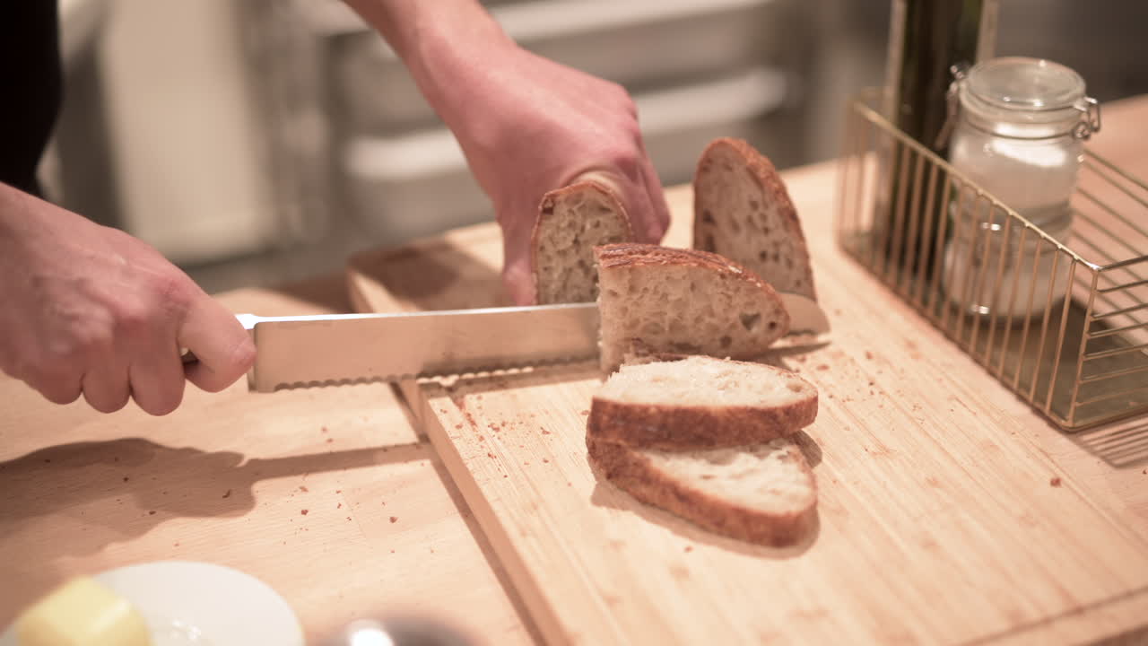 A man cuts fresh bread with a knife