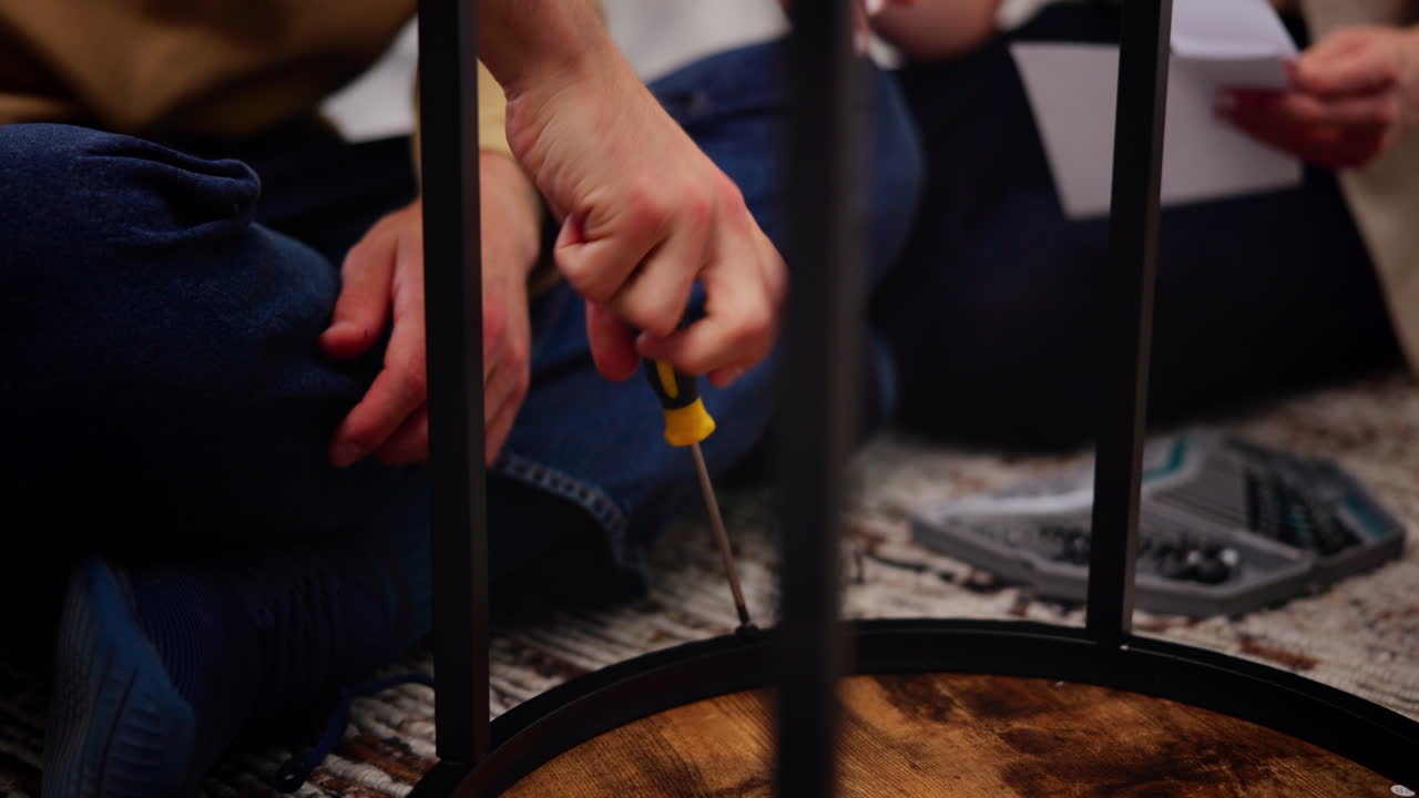 Close Up of Hands Assembling Furniture with a Screwdriver