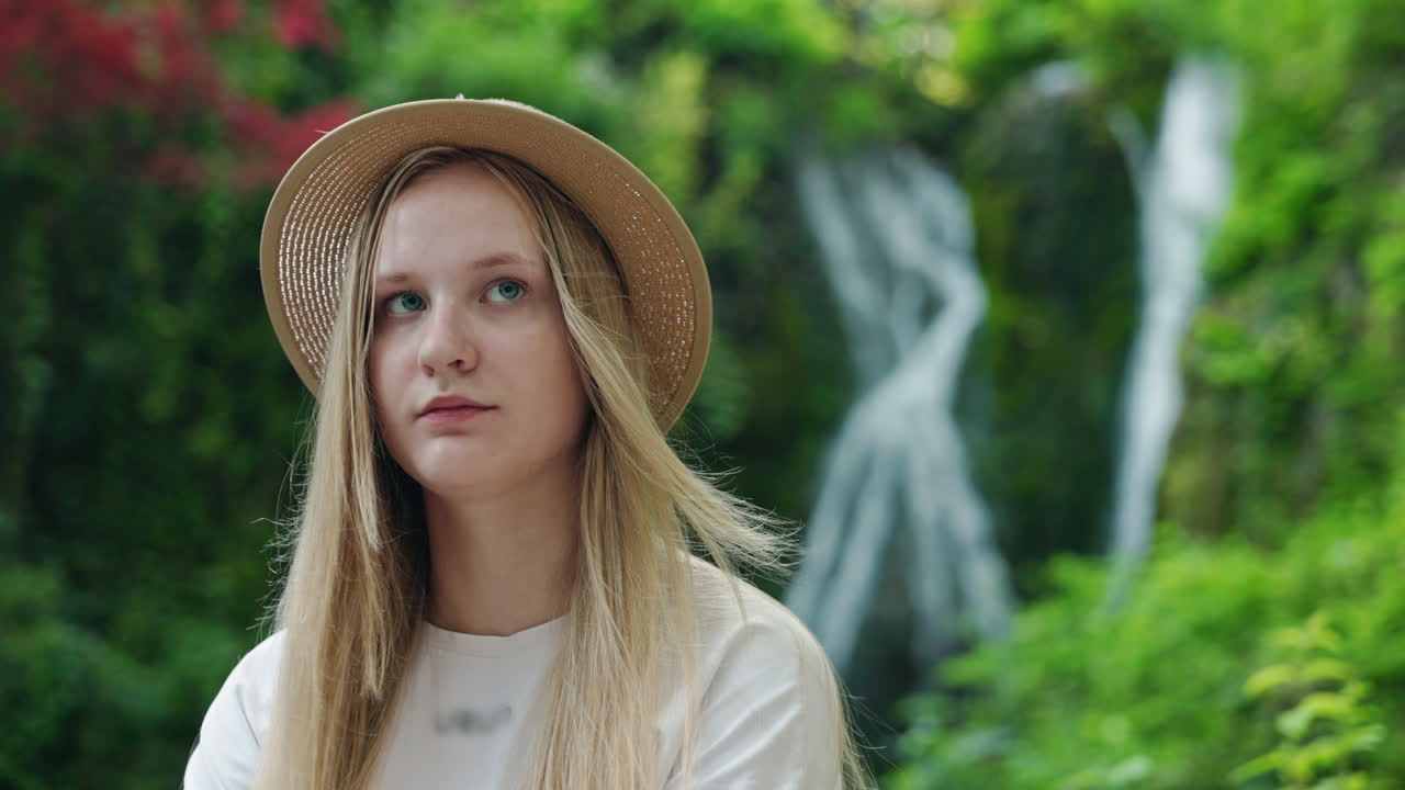 Woman in hat near waterfall