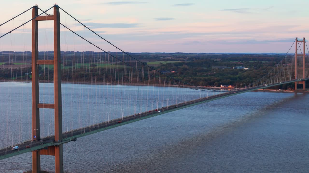 Sunset's embrace: Aerial view of Humber Bridge, cars crossing gently