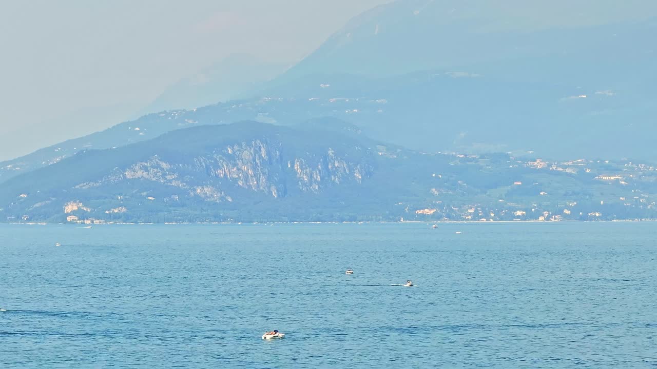 가르다 호수 에 있는 레저 보트 들, 웅장 한 산 배경