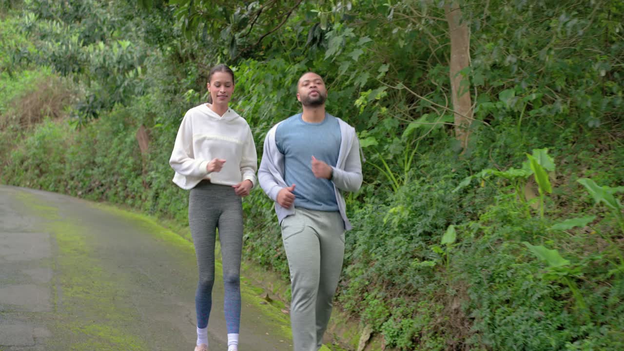 Diversi amici, motivati da un obiettivo di fitness, fanno jogging lungo un sentiero asfaltato e poi si allungano i muscoli posteriori della coscia
