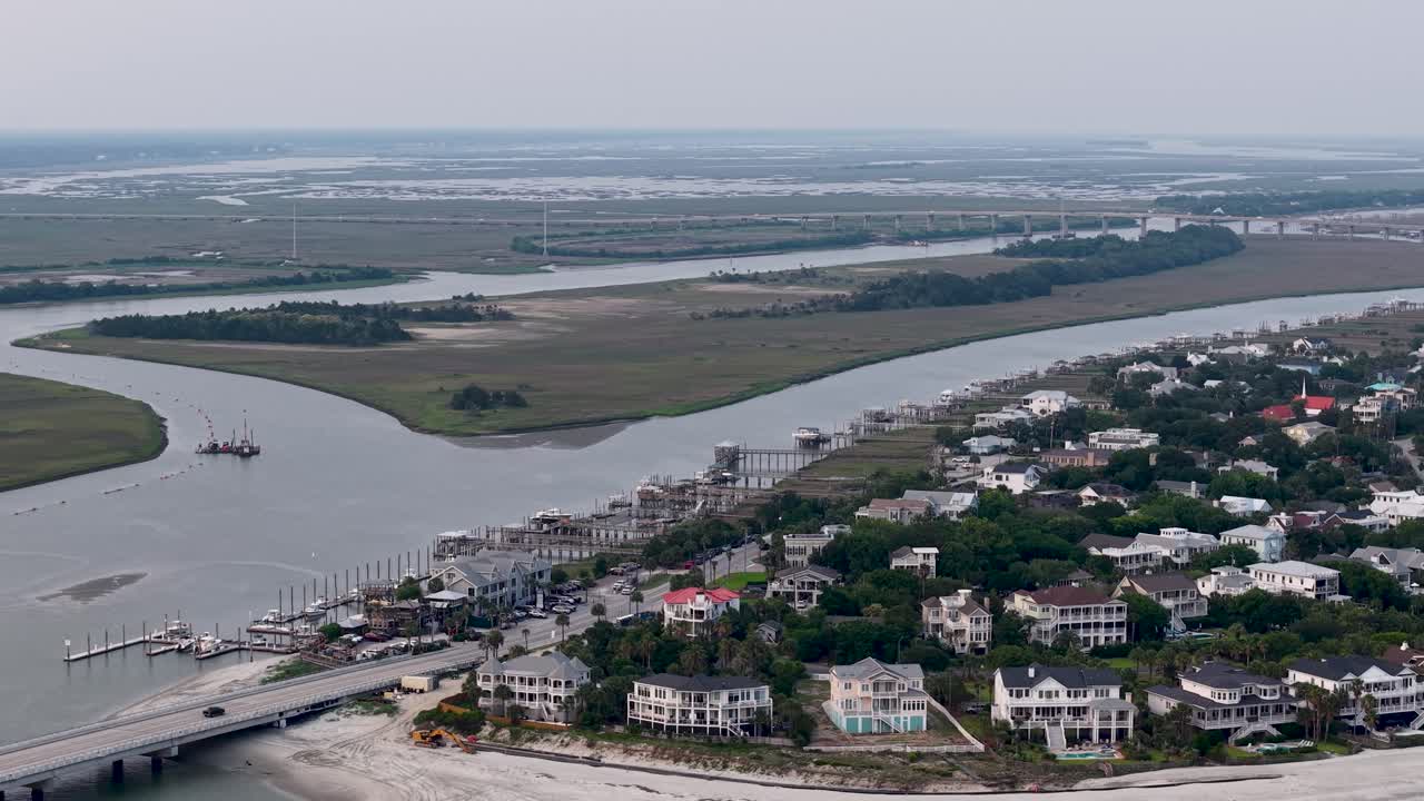 Filmato aereo di un fiume tortuoso e di una città fluviale vicino a Charleston, nella Carolina del Sud. Case lungo le sponde del fiume accanto a campi aperti, aree paludose e barche su acque calme