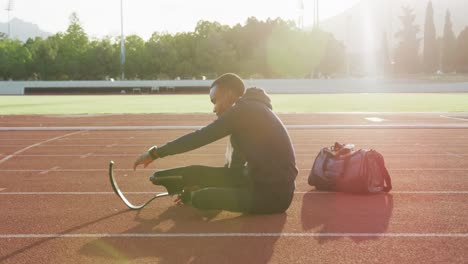 disabled mixed race man with prosthetic legs stretching before a race