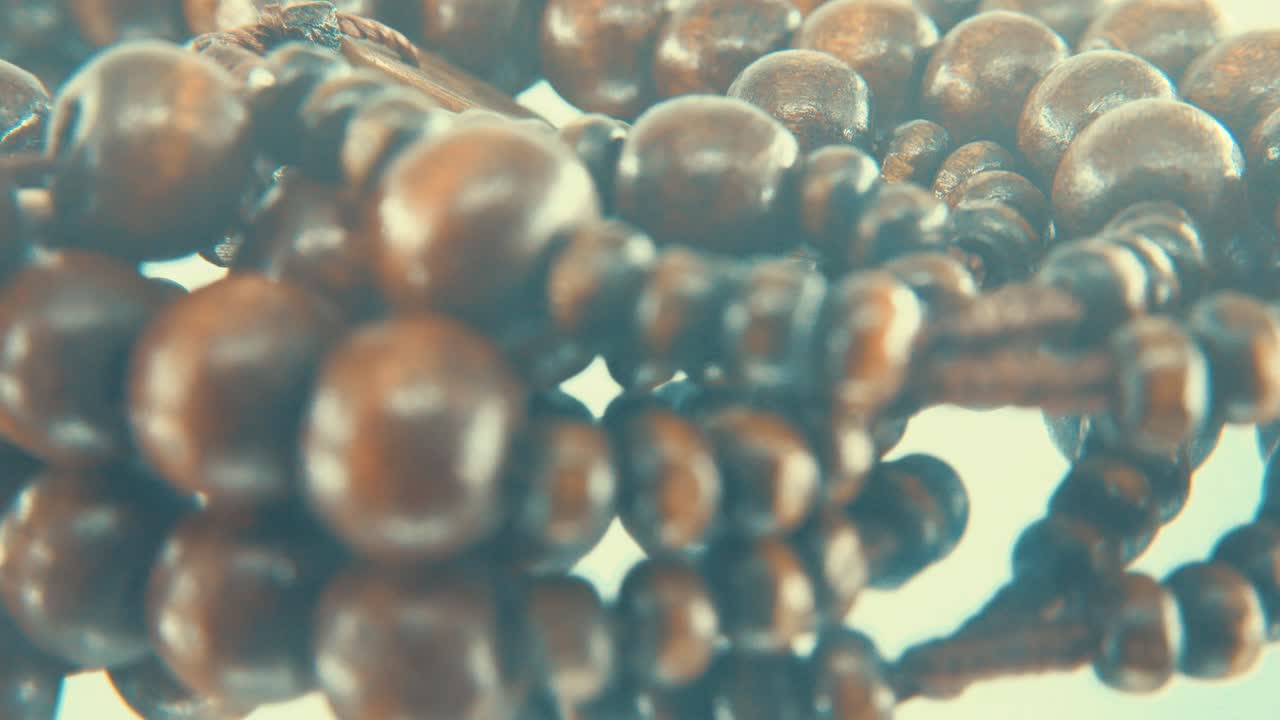 동전 메달리온이 있는 나무 둥근 구슬 목걸이의 매크로 회전 샷