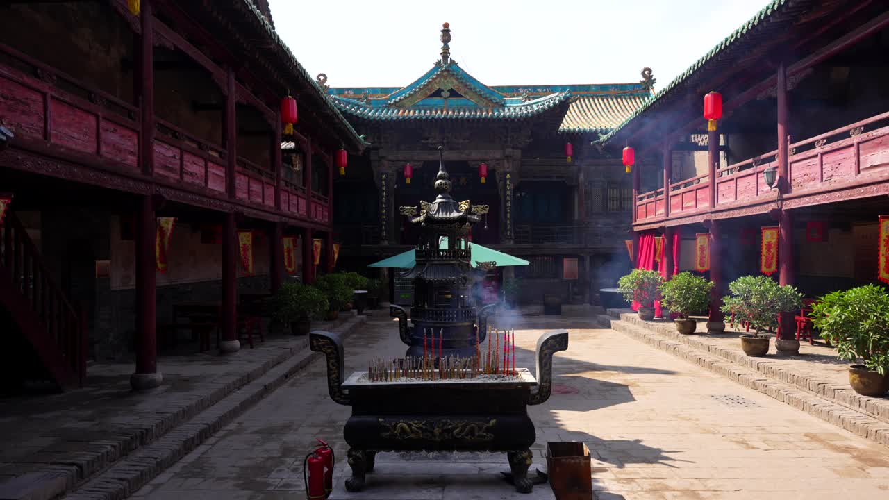 핑야오 콩푸시우스 사원 안은 은 등불과 연소하는 향소 불꽃이 있습니다.