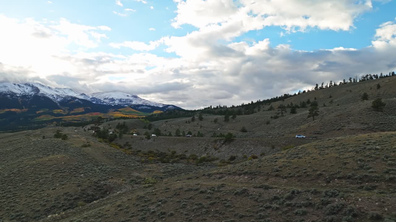 Riprese aeree panoramiche di una strada di montagna tortuosa attraverso i prati verdi di Independence Pass