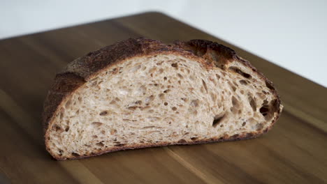 Close-up-shot-of-a-male-hand-placing-down-half-a-load-of-freshly-baked-delicious-Sourdough-bread