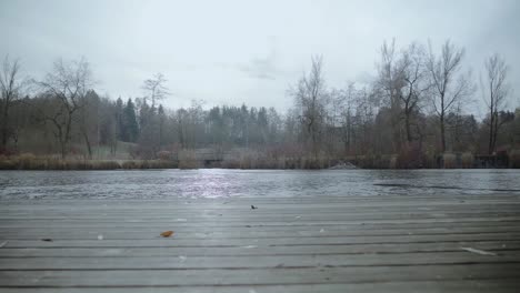 Ein-Zugefrorener-See-Mit-Einer-Brücke-Und-Einem-Einsamen-Pier,-Der-Sich-In-Winterlicher-Atmosphäre-Offenbart