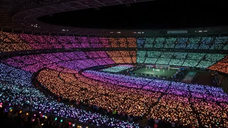 a stunning display of colorful lights illuminating a stadium during a grand event, capturing the enthusiastic energy of the crowd in spectacular fashion