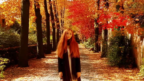 woman with red hair walking through an autumn park