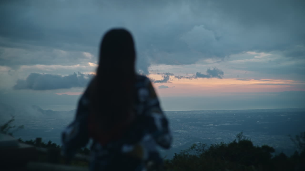 Silhouette of a woman enjoying a scenic sunset view