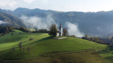 rolling fog at sunrise in the skofjelosko hribovje hills with st