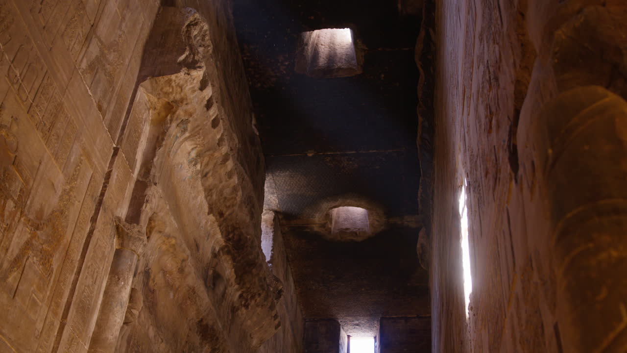 Shafts of light enter ancient stone ceiling in Dendera temple, Egypt