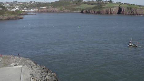 Small-fishing-vessel-returns-to-port-in-Dunmore-East-Harbour,-Ireland