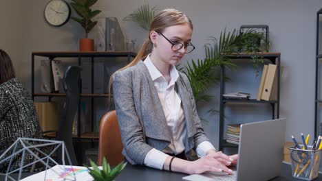 Joyful-business-woman-freelancer-concentrated-developing-new-project-while-looking-on-laptop-screen