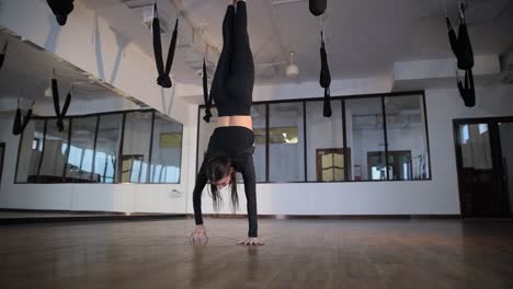 experience graceful aerial dance and fitness in an inspiring contemporary studio in a modern studio featuring unique equipment an aerial dancer impressively performs a stunning handstand
