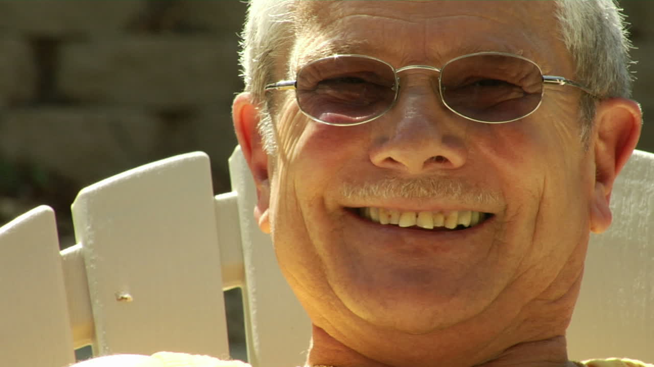 남편과 아내가 손을 잡고 잔디 의자에 앉아