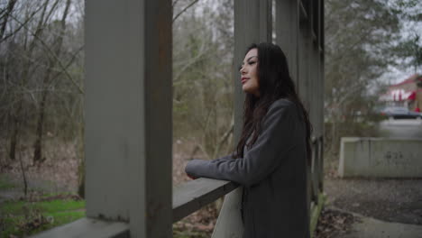 pretty woman on a wooden bridge turns to camera and smiles with recognition