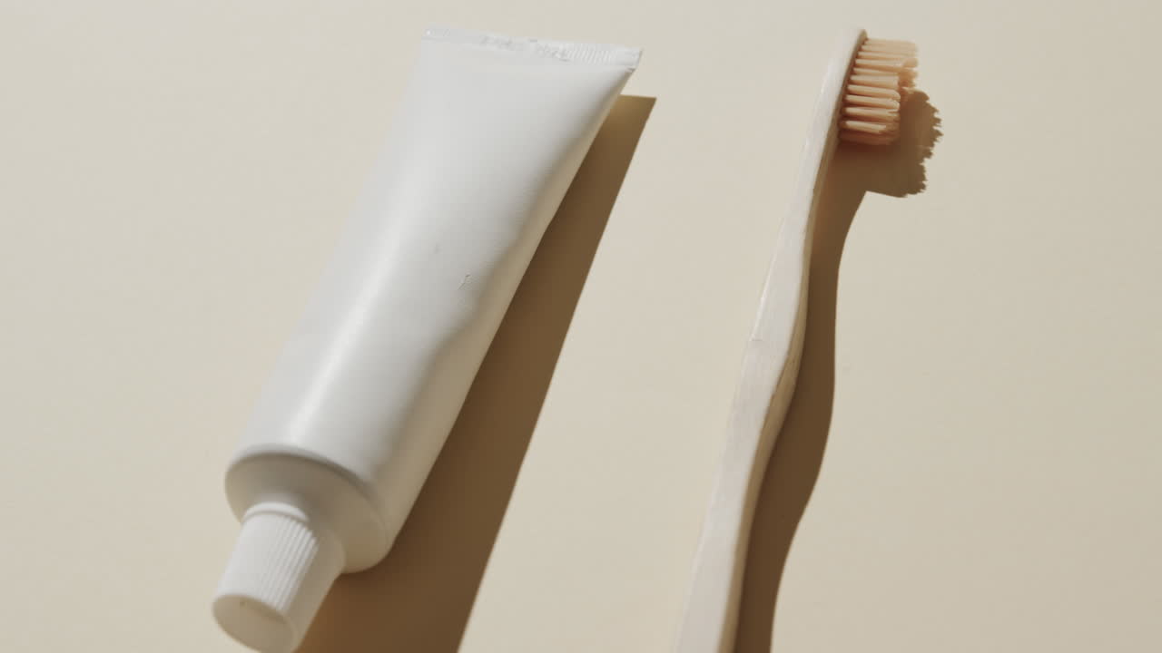 Close up of toothbrush and toothpaste on beige background