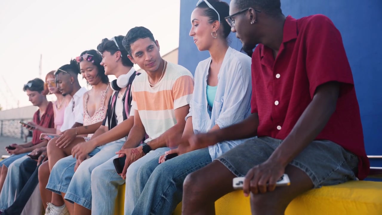 Diverse Group of Young Friends Sitting Together and Talking Outdoors