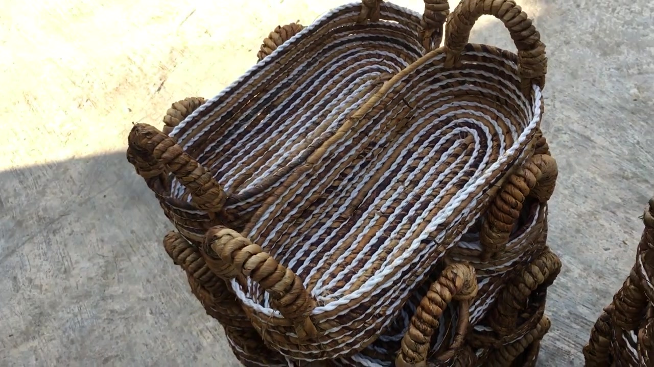 Produtos de cestaria tradicional feitos à mão são confeccionados a partir de materiais de fibra natural, como caules de bananeira, erva marinha, jacinto-d'água, e são uma mercadoria de exportação.