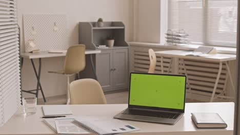 green-screened laptop on desk in office