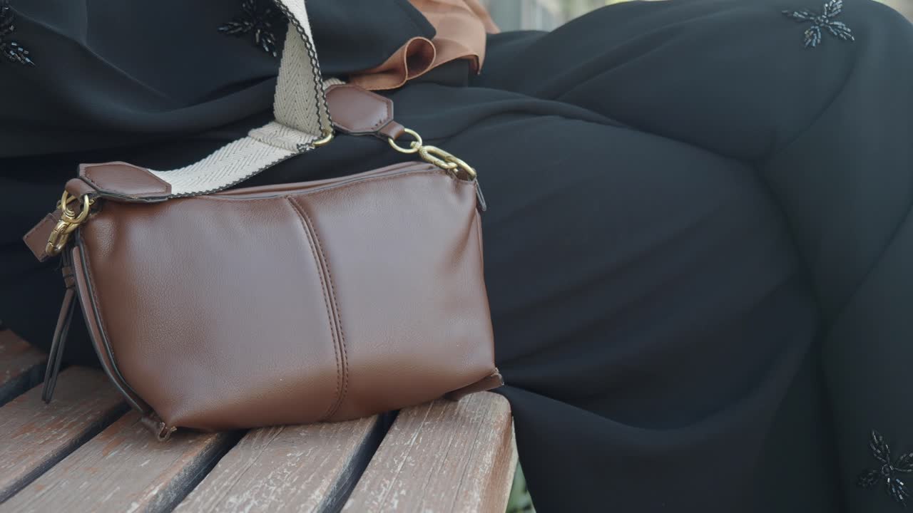Woman sitting on a bench with a brown bag