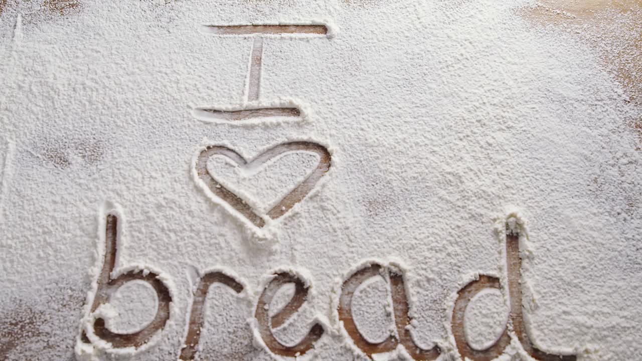 La parola "amo il pane" scritta su farina spolverata 4k