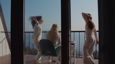 Happy Friends Dancing on Balcony with Lake View