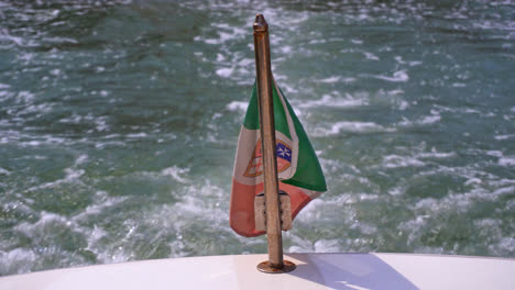 national flag of italy as civil ensign on the back of boat with backwash