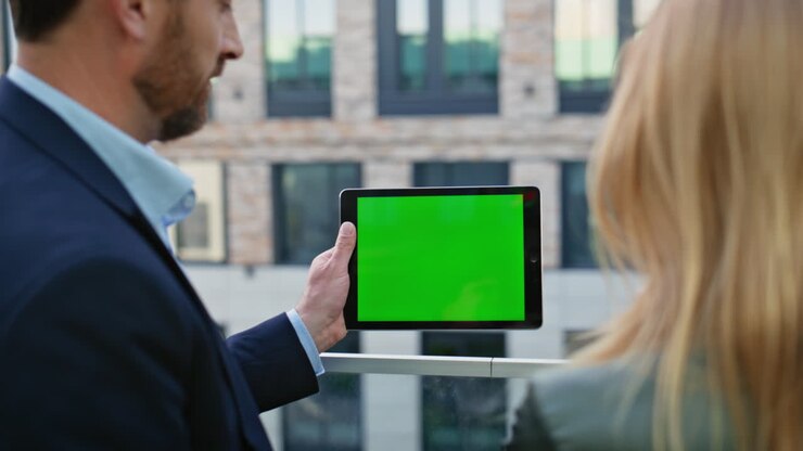Two coworkers looking mockup tablet at urban district closeup. Business couple