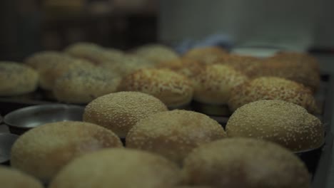 close up shot of homemade burger bread covered with seeds in cups