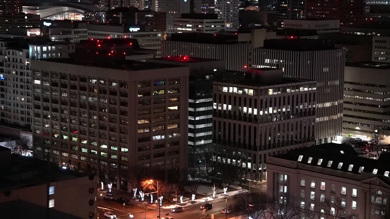 vista nocturna de invierno húmedo en la azotea de los edificios del centro de la ciudad reflejo del estadio edificios históricos posmodernos parciales árboles iluminados y postes de luces estilo festivo navidad bastante pequeño diagnol vista de pájaro