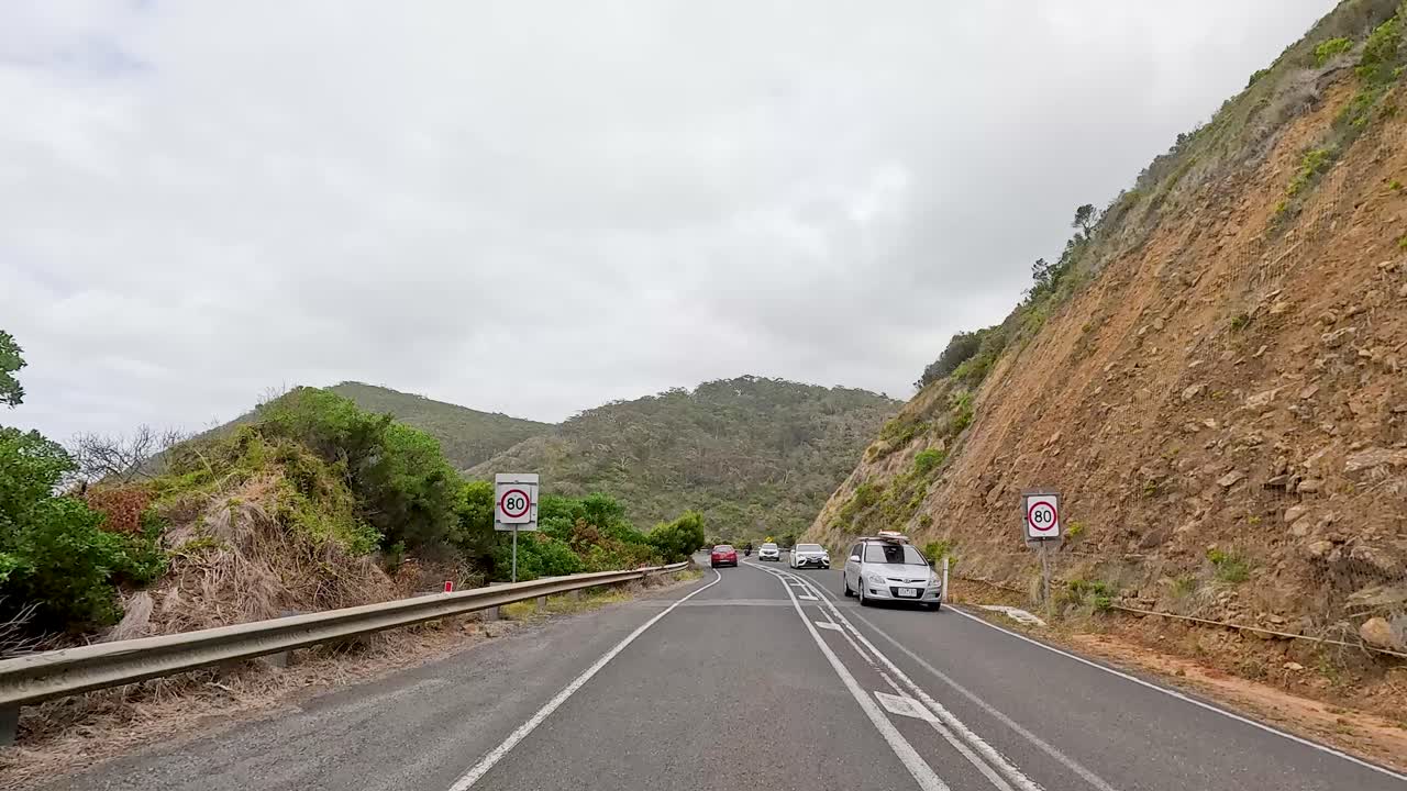 A 14-second video capturing a drive along the Great Ocean Road, showcasing coastal views and lush greenery under overcast skies