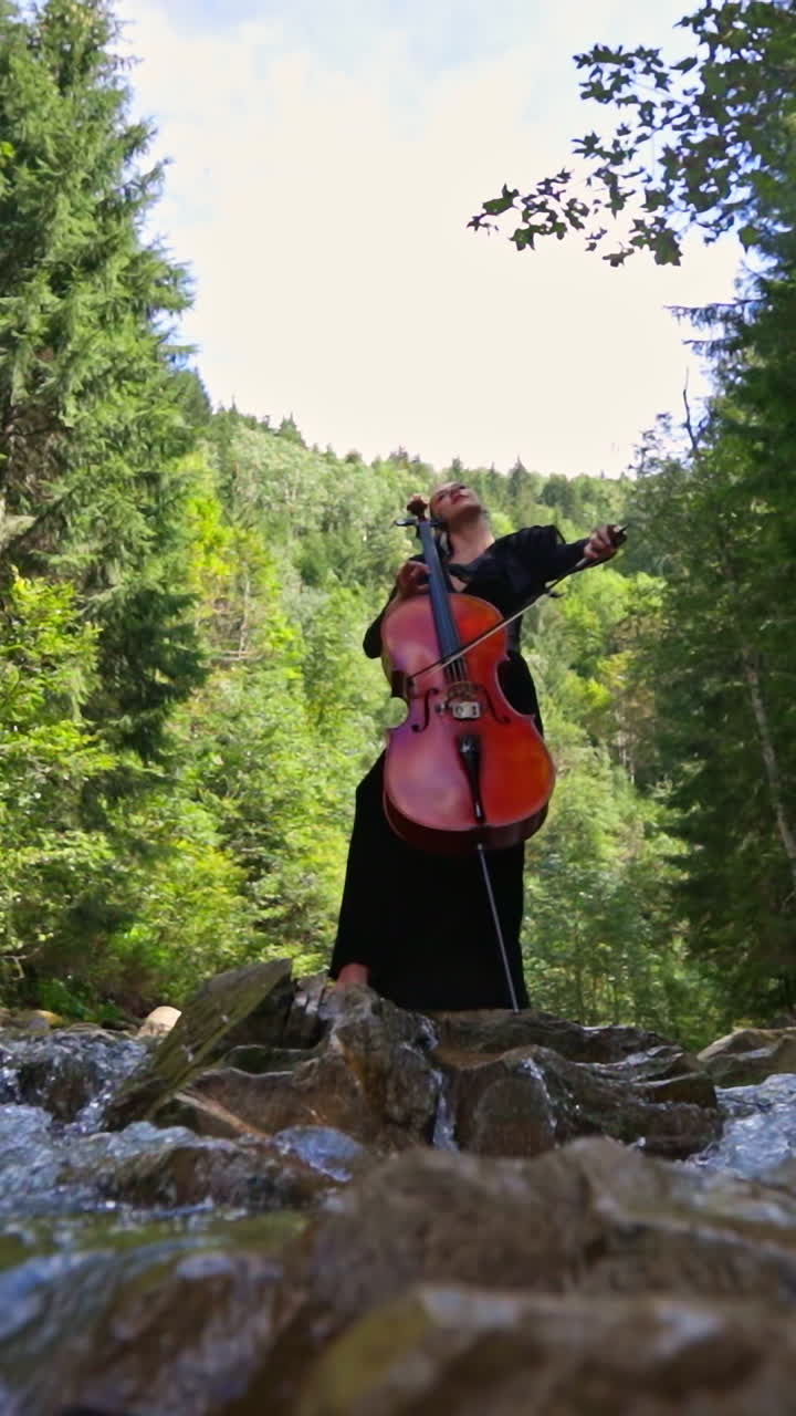 Woman Playing Cello in a Forest by a River
