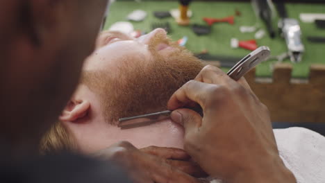 barber shaving client with straight razor