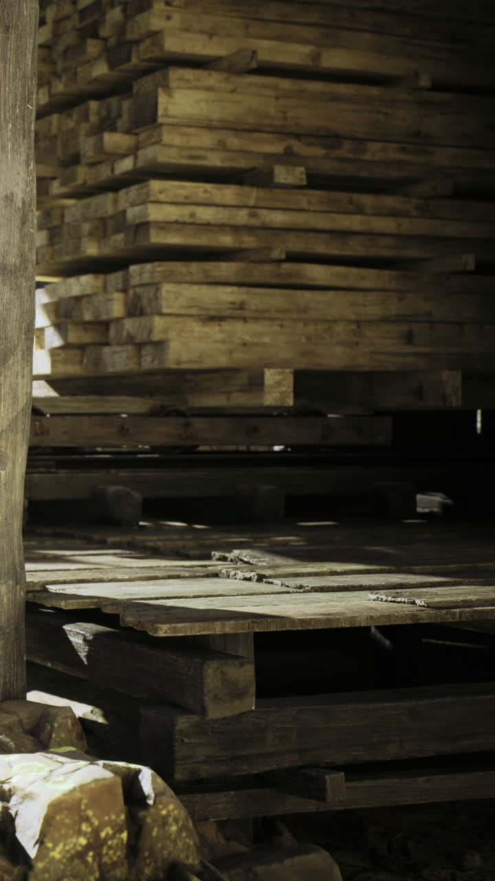 Cataste di legno creano uno sfondo rustico in un'officina dall'atmosfera serena.