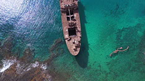 smooth aerial view flight shipwreck in turquoise green water on beach sandbank lanzarote canary islands, sunny day spain 2023