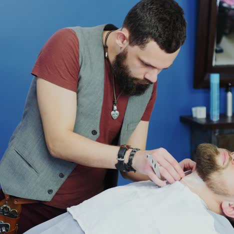 barbershop barber shaves client's beard with razor